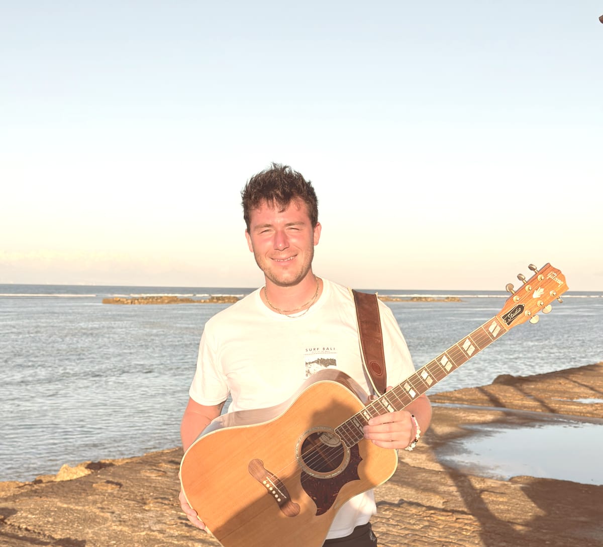Nate Couture et sa guitare au bord de la mer