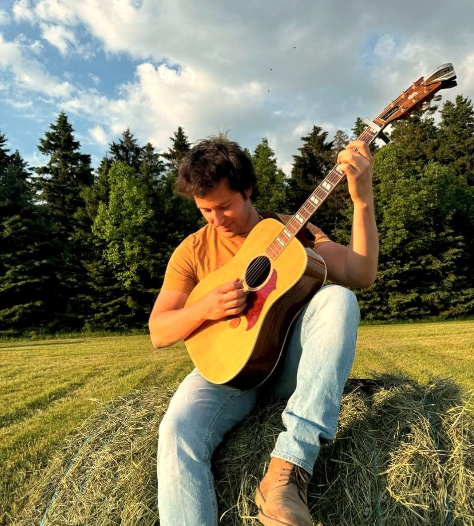 Guitare sur une balle de foin, en plein champ