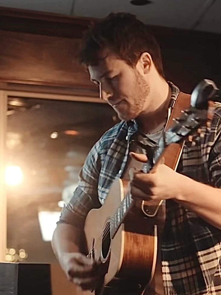 En répétition, guitare acoustique en main